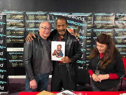 Cartoon: Fred Williamson and Ian Baker (medium) by Ian Baker tagged fred,willamson,ian,baker,cartoonist,cartoon,caricature,hollywood,legend,films,movies,actor,action,horrorcon,2026,artwork,from,dusk,till,dawn,tarrantino,linda,the,hammer